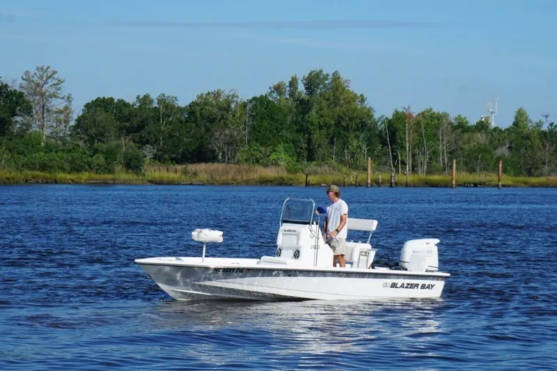 The Image of Man on a 2021 Blazer Bay boat in a scenic river setting. - 1