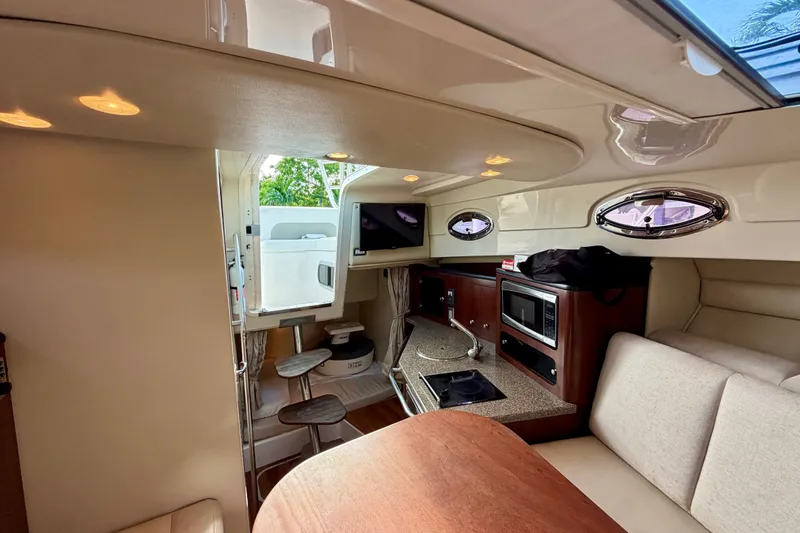 Slide: The Image of 2014 Robalo R305 Walkaround cabin interior with kitchenette and seating area. - 25