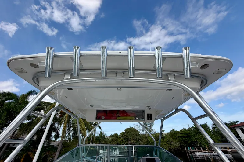 Slide: The Image of 2014 Robalo R305 Walkaround boat with rod holders, under a clear blue sky. - 16