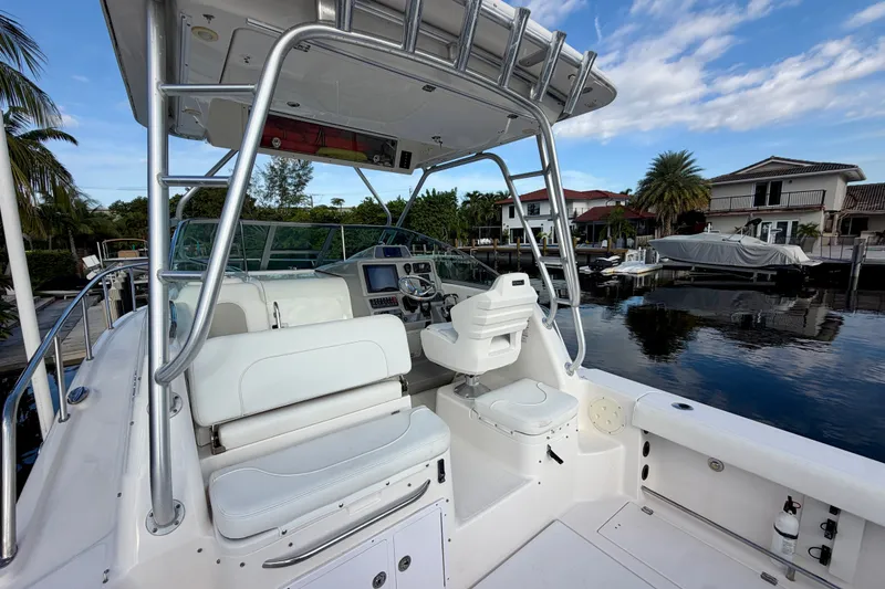 Slide: The Image of 2014 Robalo R305 Walkaround boat interior with helm, seating, and waterfront view. - 15