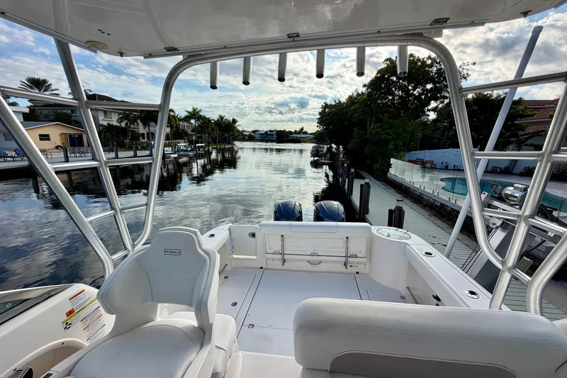 Slide: The Image of 2014 Robalo R305 Walkaround boat docked in a scenic waterfront setting. - 14