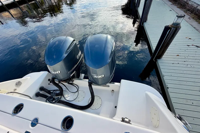 Slide: The Image of 2014 Robalo R305 Walkaround with twin Yamaha 300 engines docked by the water. - 21