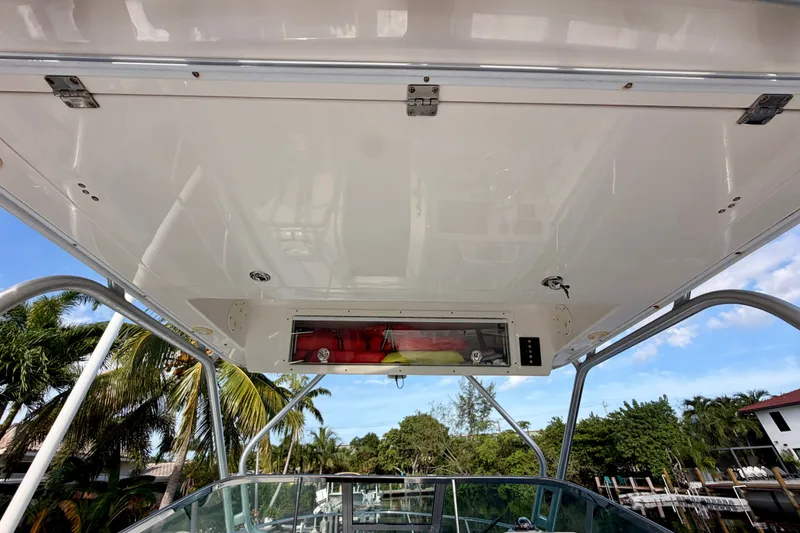 Slide: The Image of 2014 Robalo R305 Walkaround boat canopy with clear sky and palm trees in background. - 17