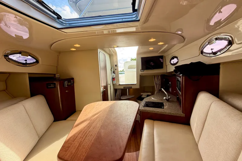 Slide: The Image of 2014 Robalo R305 Walkaround cabin interior with seating, kitchenette, and skylight. - 23