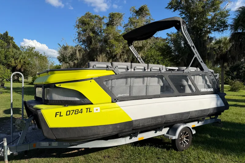 The Image of 2023 Sea-Doo Switch Sport 21 on trailer, vibrant yellow and gray design, parked outdoors. - 3