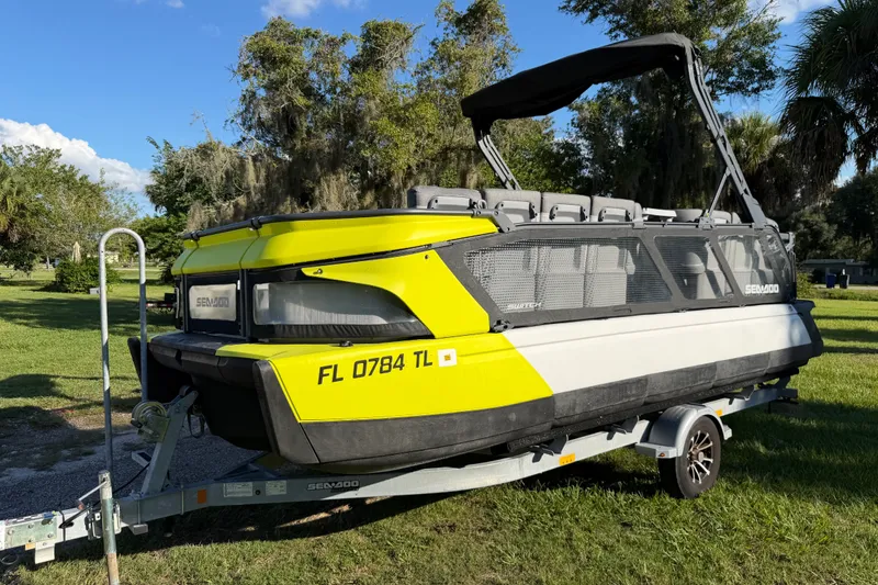 Slide: The Image of 2023 Sea-Doo Switch Sport 21 on trailer, parked on grass under clear sky. - 15