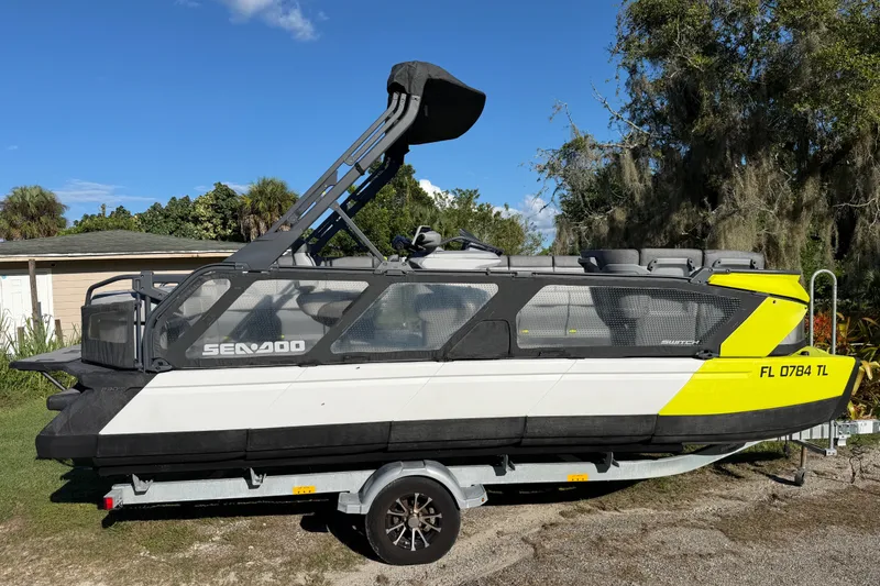 Slide: The Image of 2023 Sea-Doo Switch Sport 21 on trailer, parked outdoors under clear blue sky. - 4
