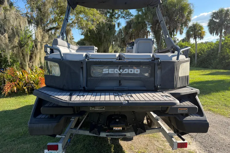 Slide: The Image of 2023 Sea-Doo Switch Sport 21 pontoon boat on trailer, rear view, outdoor setting. - 5
