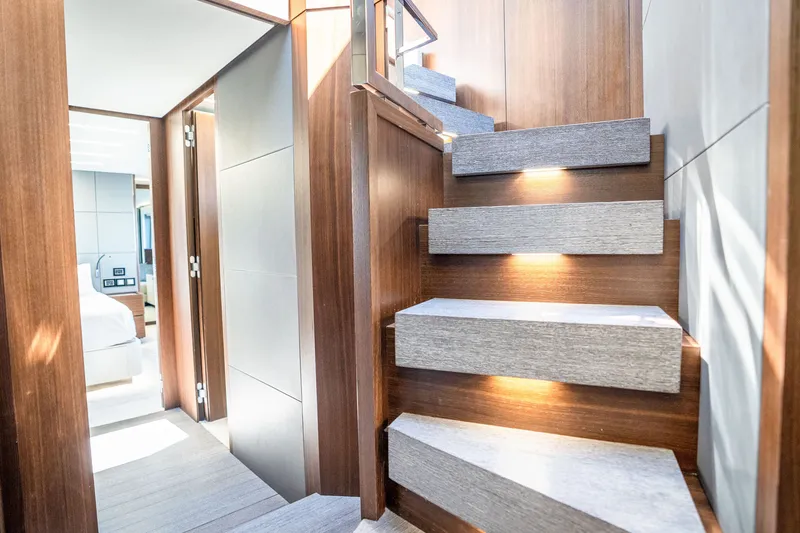 Slide: The Image of Luxurious interior staircase of 2022 Astondoa 66 Fly yacht, featuring elegant wood and lighting. - 34