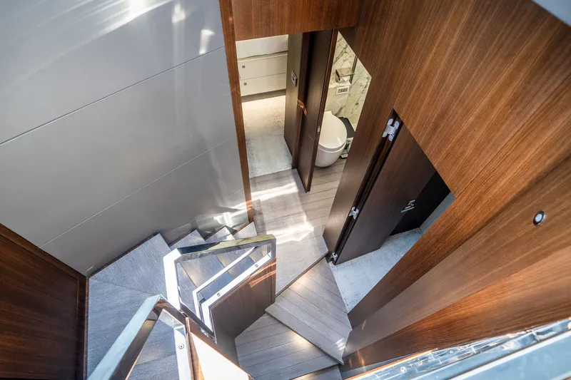 Slide: The Image of Interior staircase of 2022 Astondoa 66 Fly yacht, featuring modern wood paneling and sleek design. - 33