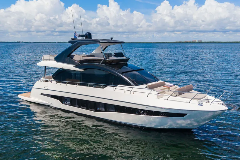 Slide: The Image of Luxury 2022 Astondoa 66 Fly yacht cruising on open water under a clear sky. - 3