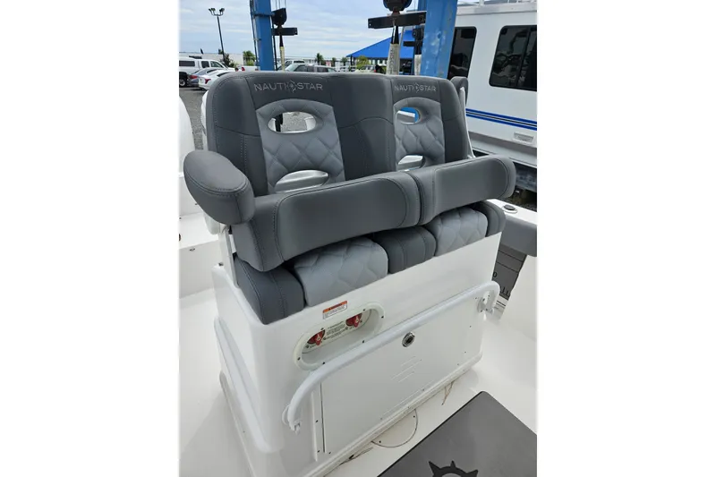 Slide: The Image of Gray cushioned seats on 2025 NauticStar 252 Legacy boat, featuring armrests and storage compartment. - 5