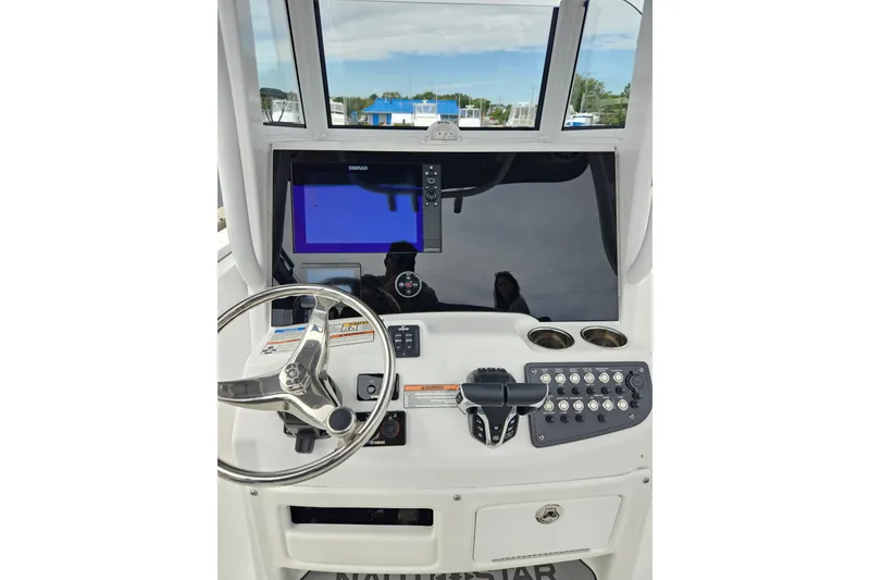 Slide: The Image of 2025 NauticStar 252 Legacy boat dashboard with steering wheel and navigation controls. - 3