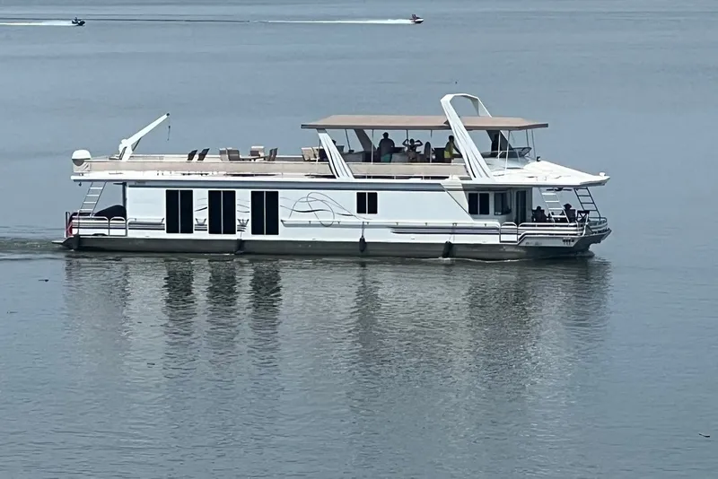 Slide: The Image of 1999 Fantasy 75' x 17' Custom houseboat cruising on calm water. - 1