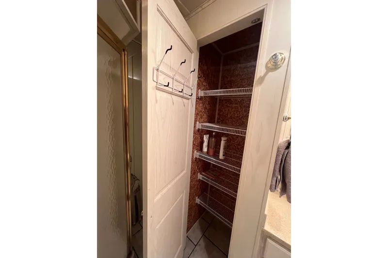 Slide: The Image of Small closet with wire shelves in a 1999 Fantasy Custom houseboat bathroom. - 42