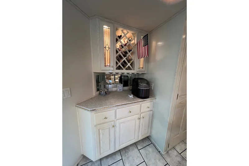 Slide: The Image of Cozy kitchen corner in 1999 Fantasy Custom boat with wine rack and American flag. - 31