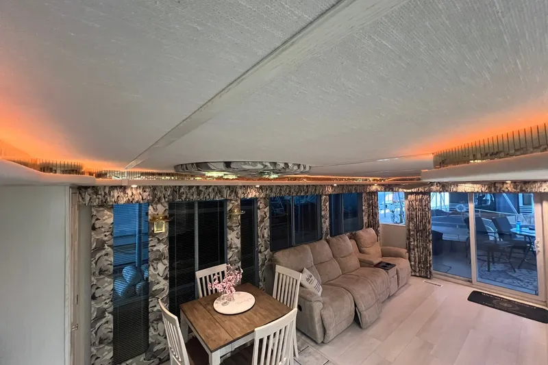 Slide: The Image of Interior of a 1999 Fantasy Custom houseboat with cozy seating and dining area. - 25