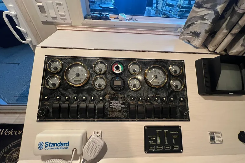 Slide: The Image of Control panel of a 1999 Fantasy 75' x 17' Custom boat with gauges and switches. - 33