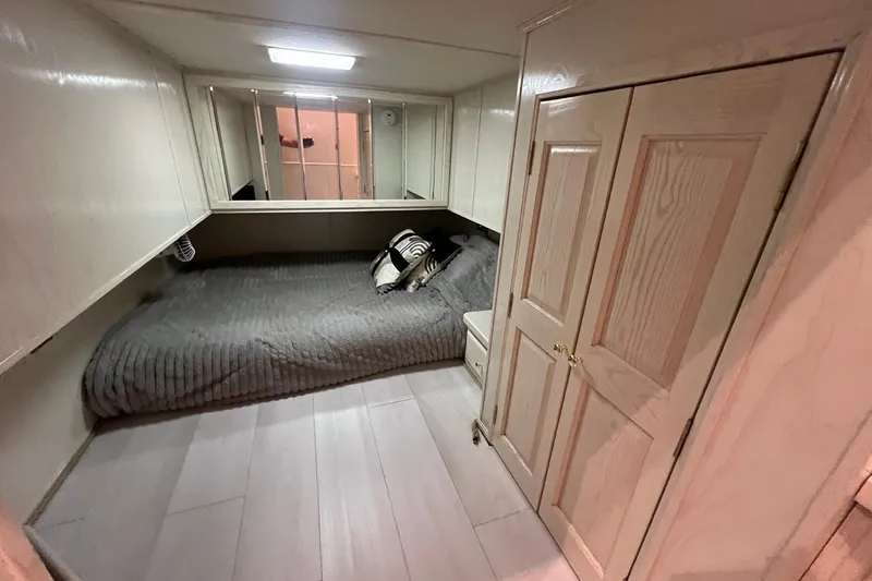 Slide: The Image of Cozy bedroom in a 1999 Fantasy Custom houseboat, featuring a comfortable bed and wooden cabinetry. - 35