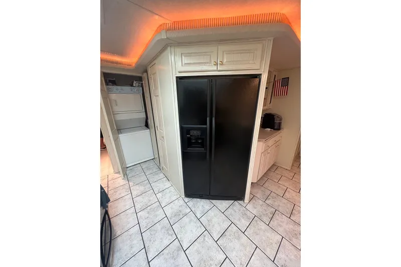 Slide: The Image of Modern kitchen with black refrigerator, washer-dryer, and tiled floor in a 1999 Fantasy Custom houseboat. - 28