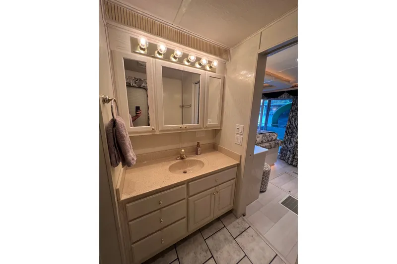 Slide: The Image of Bathroom vanity in a 1999 Fantasy 75' x 17' Custom houseboat, featuring ample storage and lighting. - 40