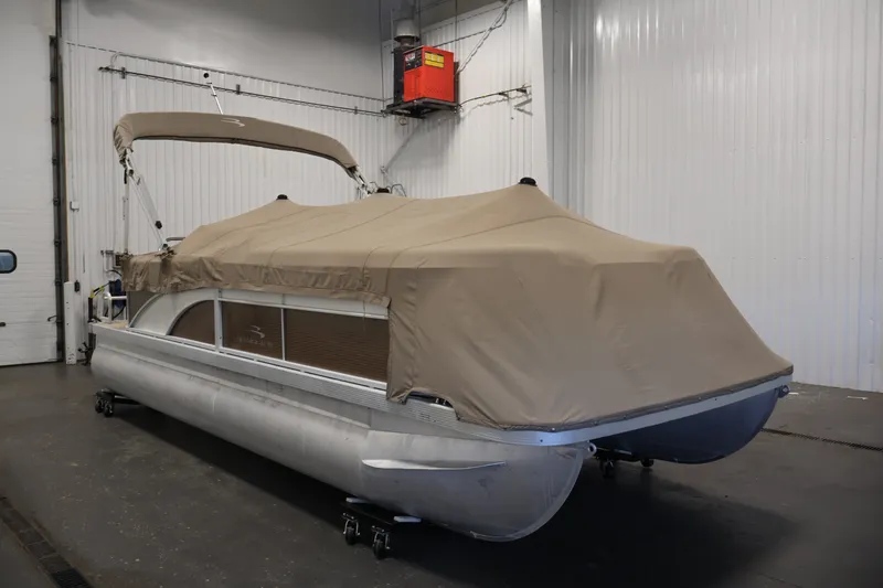 Slide: The Image of 2017 Bennington 21 SL pontoon boat with beige cover in indoor storage. - 35