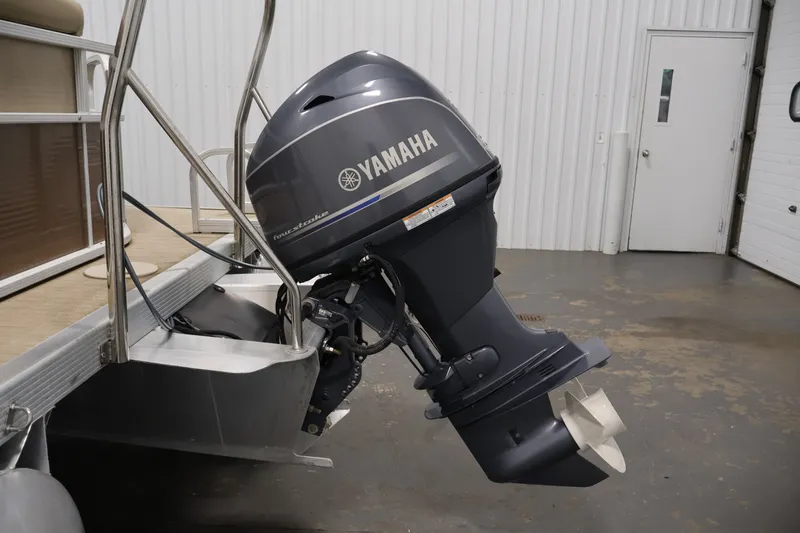 Slide: The Image of 2017 Bennington 21 SL pontoon boat with Yamaha outboard motor in a garage setting. - 32