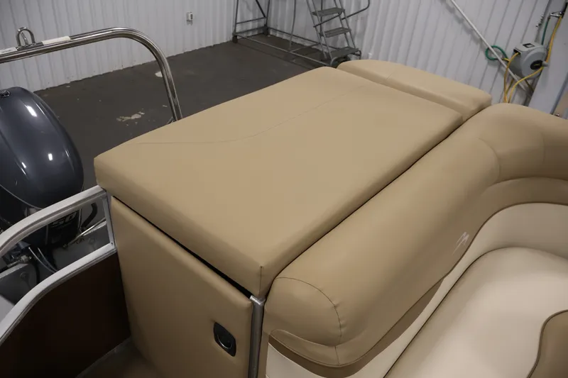 Slide: The Image of 2017 Bennington 21 SL boat interior with beige seating and motor in a garage. - 28