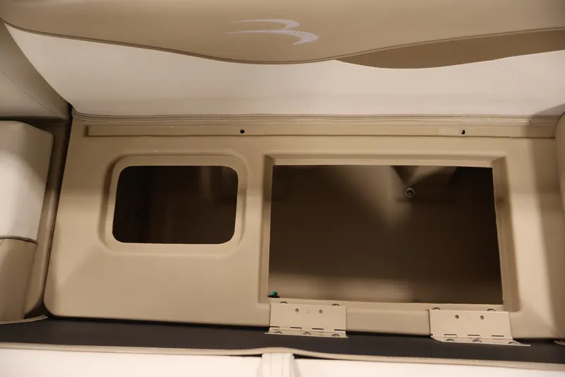 Slide: The Image of Interior storage compartment of a 2017 Bennington 21 SL boat, featuring beige upholstery. - 27