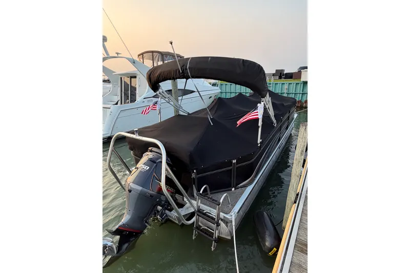 Slide: The Image of 2012 Premier 250 Grand Majestic LTD boat docked with cover and flags. - 24