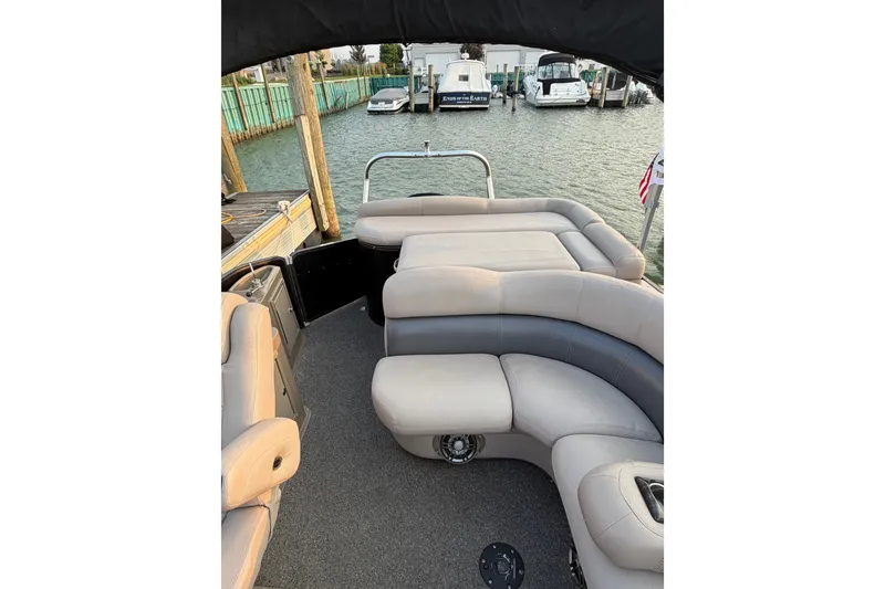 Slide: The Image of 2012 Premier 250 Grand Majestic LTD pontoon boat interior with plush seating at dock. - 13