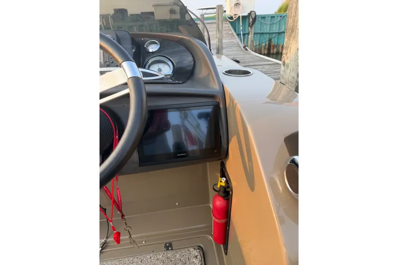Slide: The Image of Steering console of 2012 Premier 250 Grand Majestic LTD boat with gauges and fire extinguisher. - 18