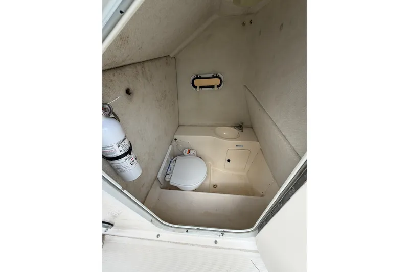 Slide: The Image of 2001 Pursuit 2470 Center Console boat interior with toilet, sink, and fire extinguisher. - 12