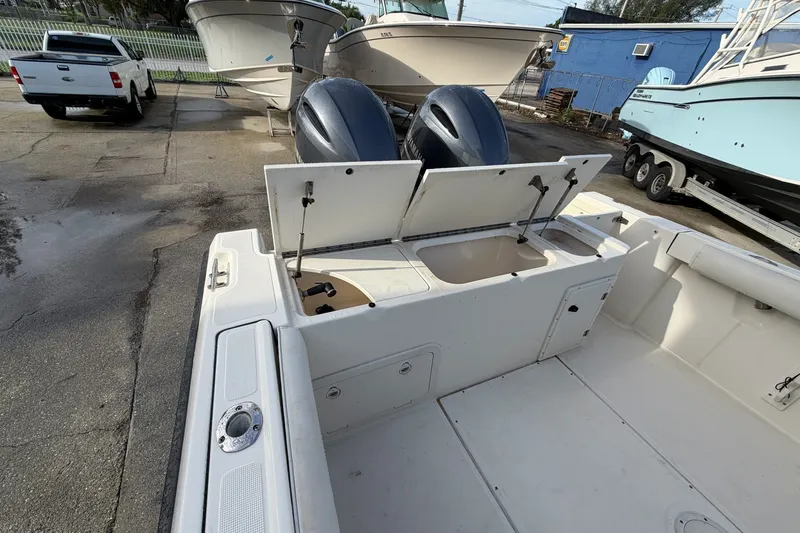 Slide: The Image of 2001 Pursuit 2470 Center Console boat with open storage compartments and dual engines. - 16