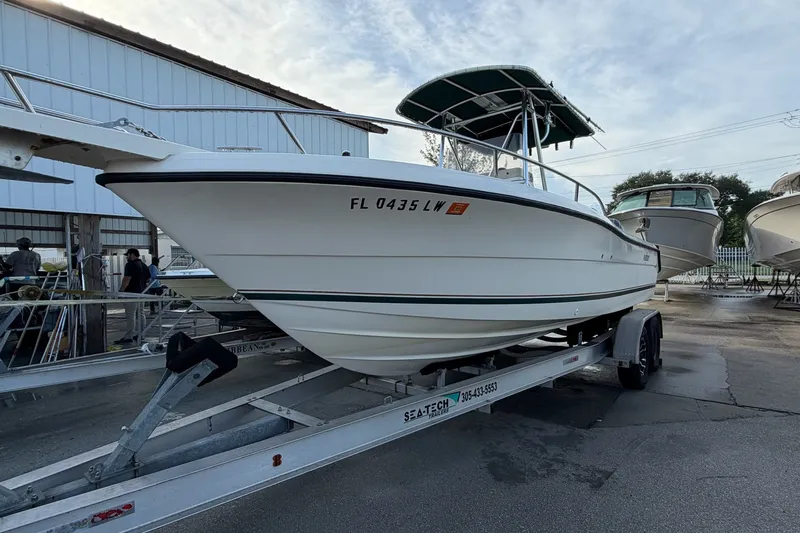 Slide: The Image of 2001 Pursuit 2470 Center Console boat on trailer, parked outdoors. - 1