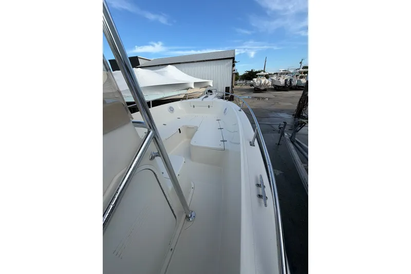 Slide: The Image of 2001 Pursuit 2470 Center Console boat docked, showcasing spacious deck and sleek design. - 8