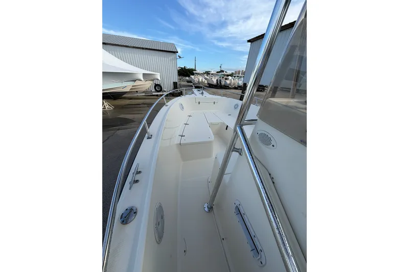 Slide: The Image of 2001 Pursuit 2470 Center Console boat docked, showcasing spacious deck and sleek design. - 7