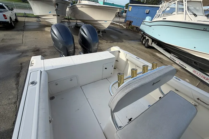 Slide: The Image of 2001 Pursuit 2470 Center Console boat with dual outboard engines in a marina setting. - 13
