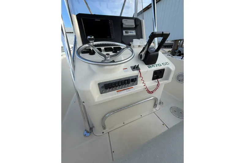 Slide: The Image of 2001 Pursuit 2470 Center Console boat dashboard with steering wheel and controls. - 4
