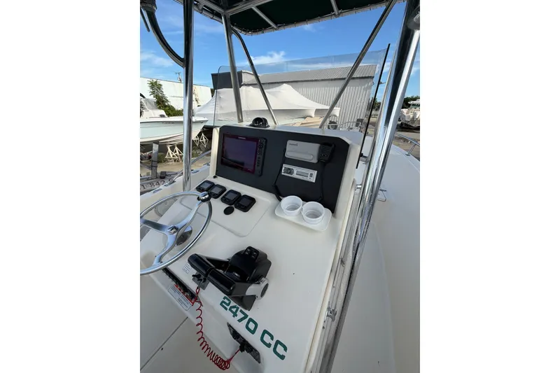 Slide: The Image of 2001 Pursuit 2470 Center Console boat dashboard with steering wheel and navigation equipment. - 3