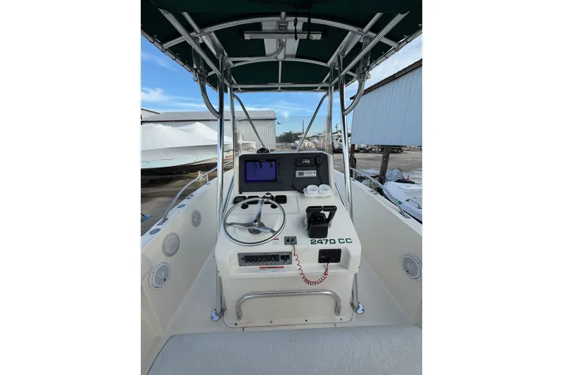 Slide: The Image of 2001 Pursuit 2470 Center Console boat interior with steering wheel and navigation equipment. - 2