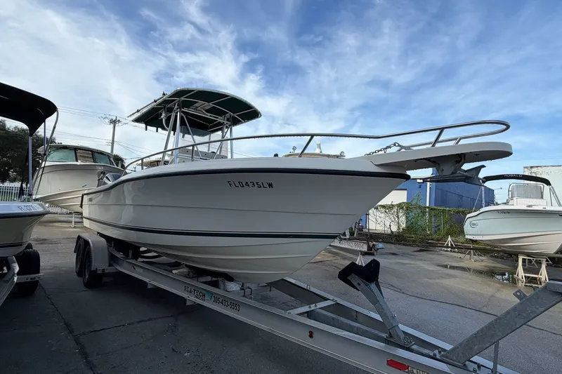 The Image of 2001 Pursuit 2470 Center Console boat on trailer, parked outdoors under blue sky. - 0