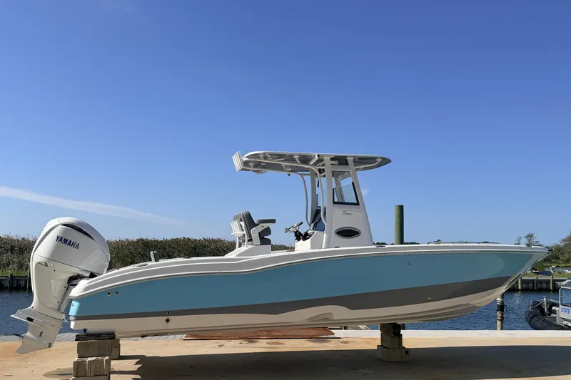 The Image of 2025 NauticStar 251 Hybrid boat with Yamaha engine, docked under clear blue sky. - 0