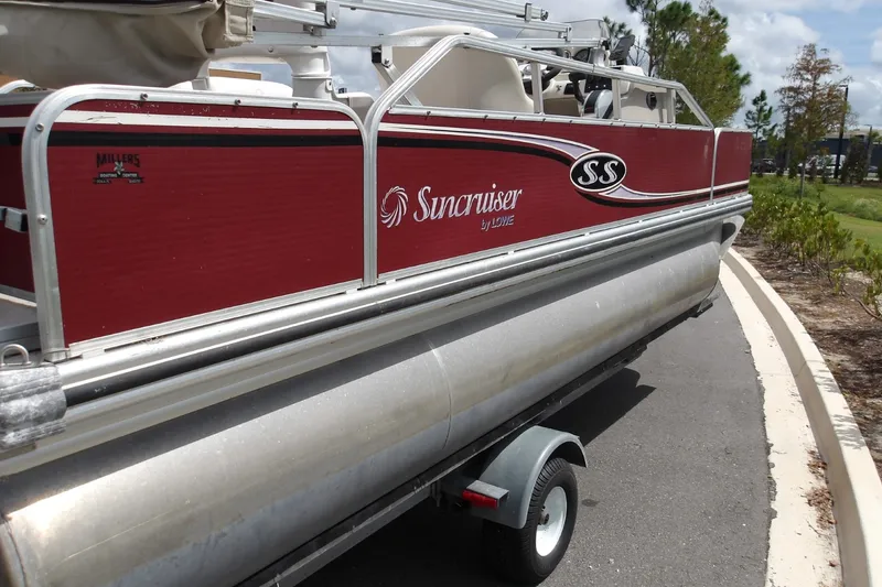 Slide: The Image of 2010 Lowe SF 194 Sport Fish pontoon boat on trailer, red exterior, parked on road. - 8
