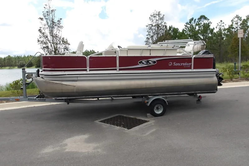 The Image of 2010 Lowe SF 194 Sport Fish pontoon boat on trailer by a lake. - 1