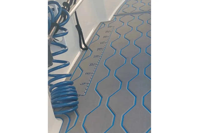 Slide: The Image of 2019 Tidewater 210 CC Adventure boat deck with blue coiled hose and measurement markings. - 8