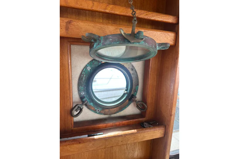 Slide: The Image of Porthole window on 2009 Ranger Tugs R-25 boat, featuring aged brass and wooden interior. - 34