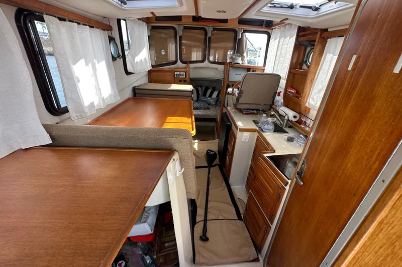 Slide: The Image of Interior of a 2009 Ranger Tugs R-25 boat with wood finishes and compact kitchen. - 19