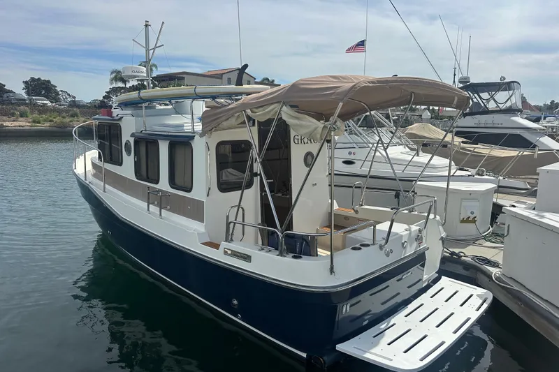 Slide: The Image of 2009 Ranger Tugs R-25 boat docked at marina with canopy and American flag. - 6