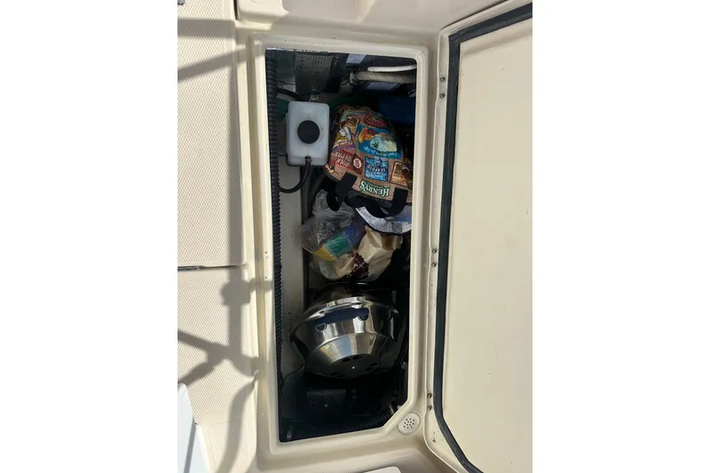 Slide: The Image of Storage compartment in a 2009 Ranger Tugs R-25 boat, containing various items. - 16
